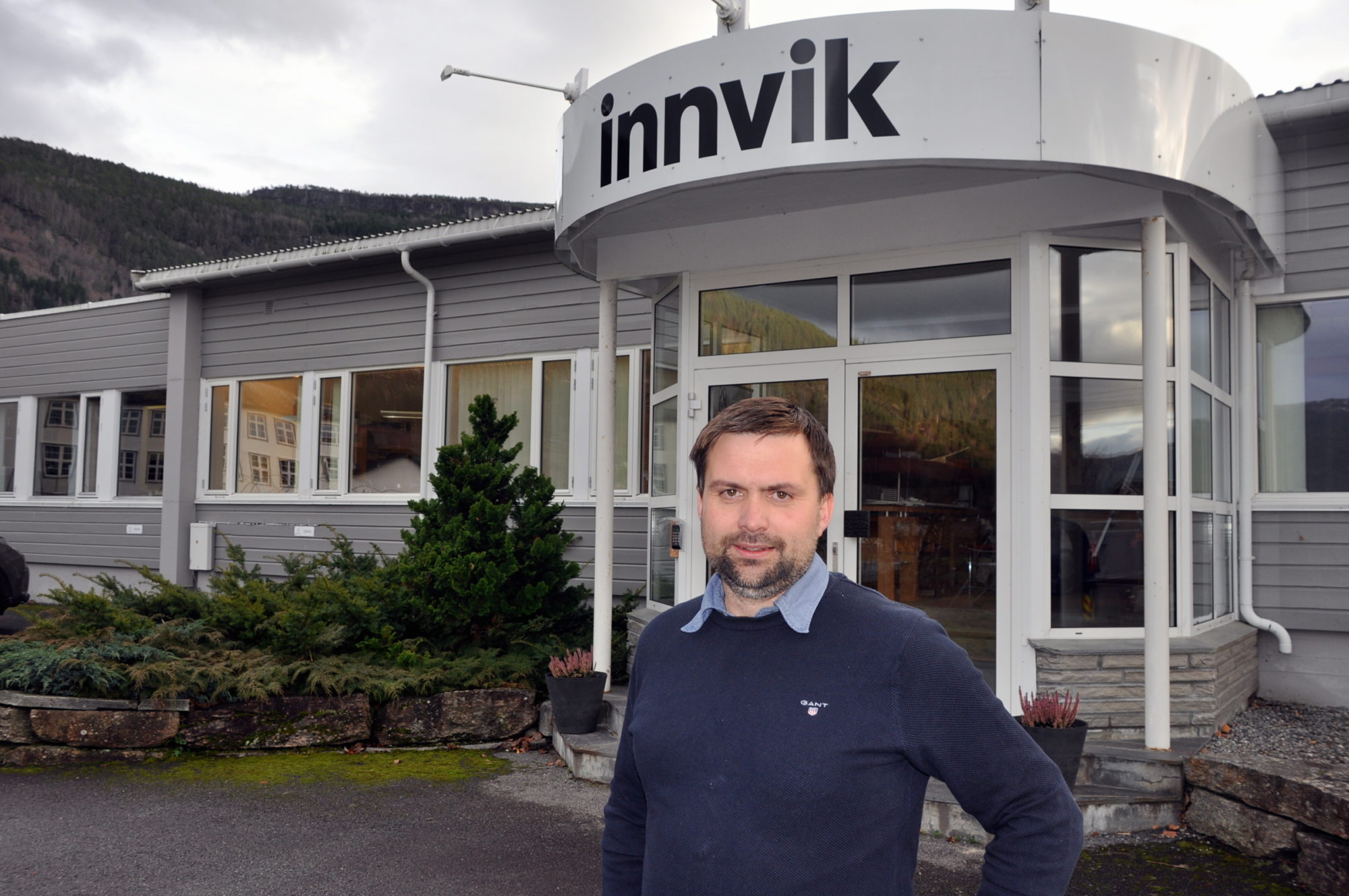 Bildet viser daglig leder Bjørn Aage Haugen som står foran inngangen til fabrikklokalene til Innvik.