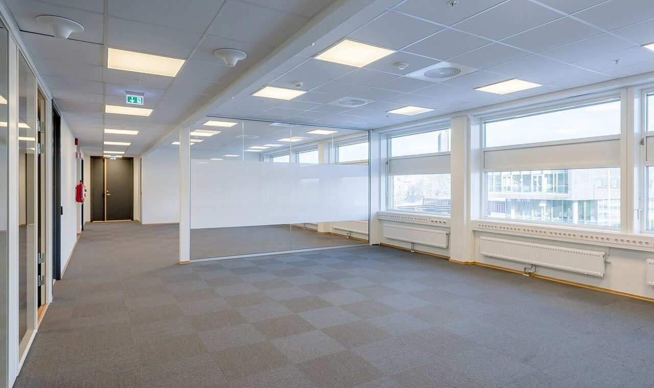 Bildet viser et tomt rom med skillevegger av glass