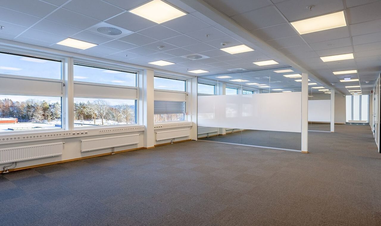 Bildet viser et tomt rom med skillevegger av glass