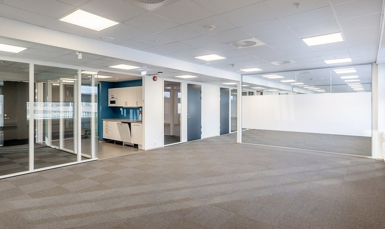 Bilde viser et tomt kontorlokale med skillevegg av glass