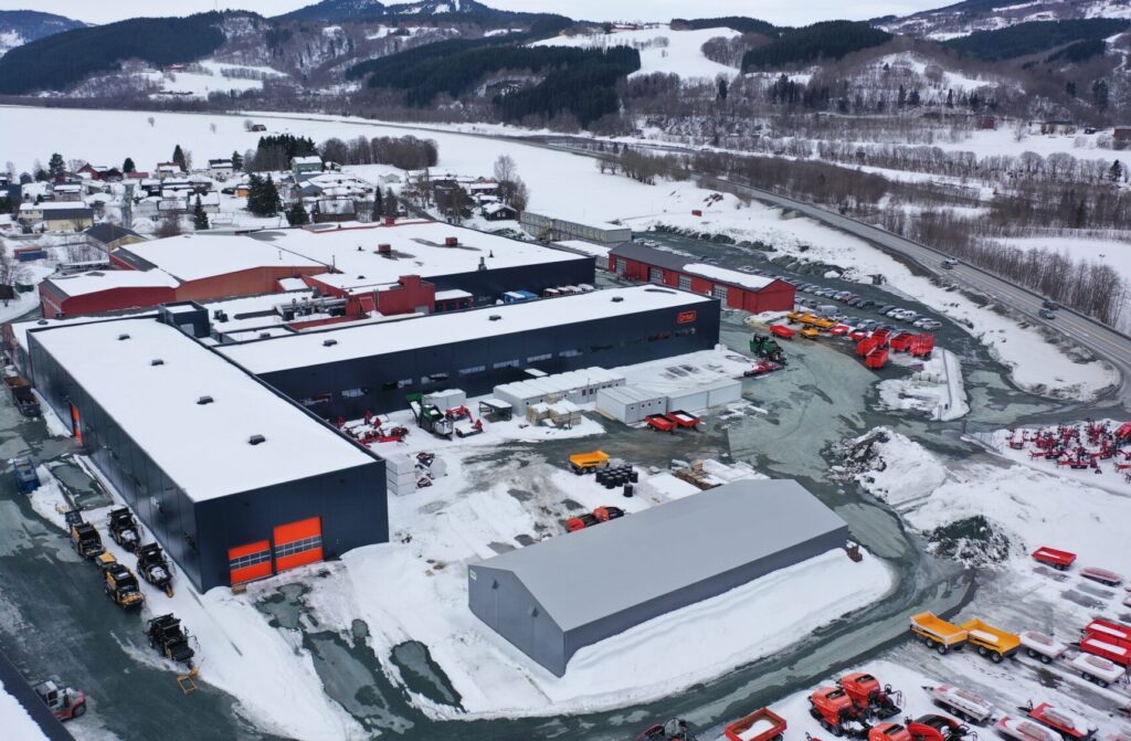 Bildet viser et industriområde med flere bygg bestående av produksjonsbygg, lager og administrasjonsbygg.